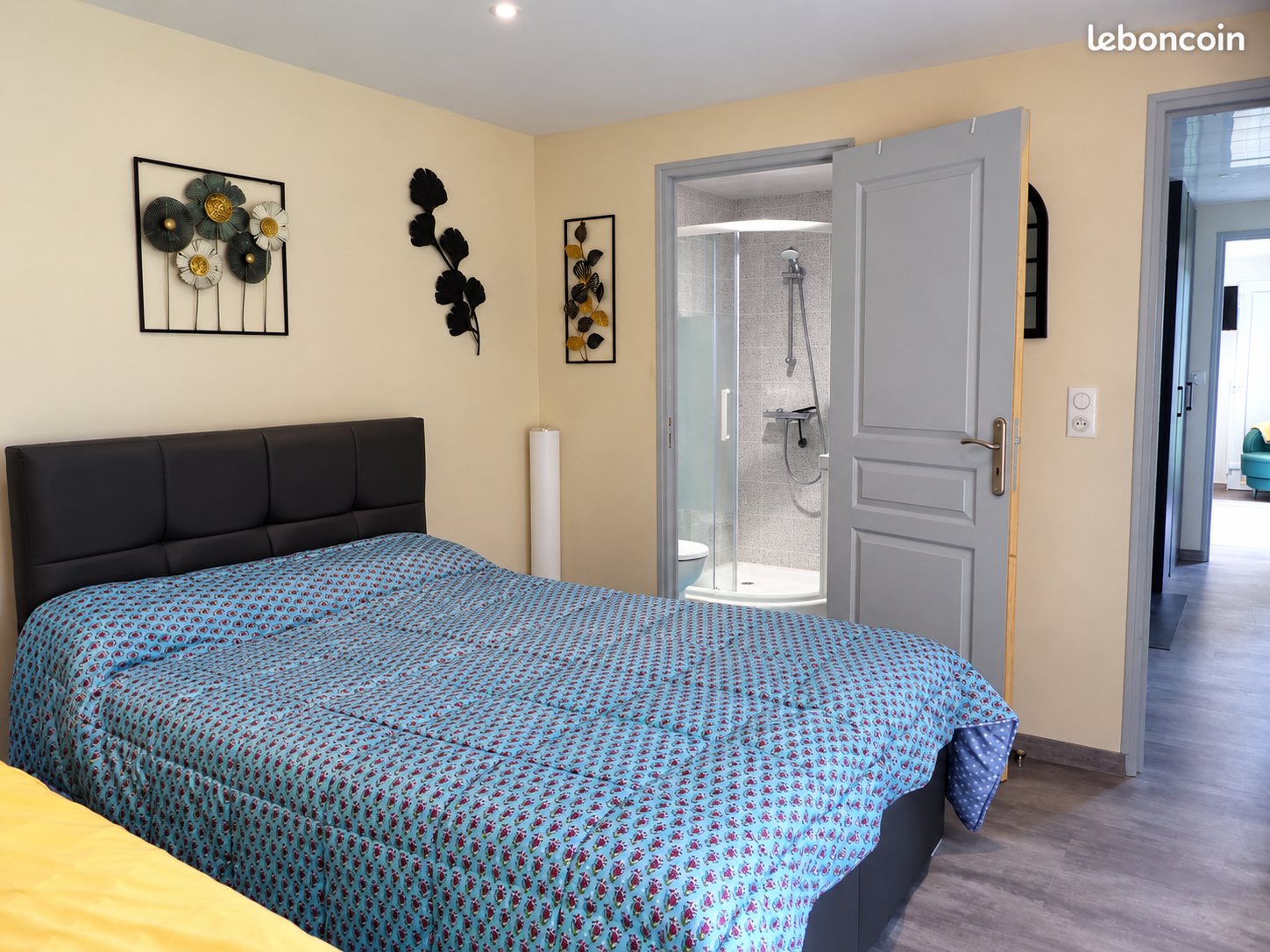 Chambre avec lit double, salle d’eau et couloir lumineux