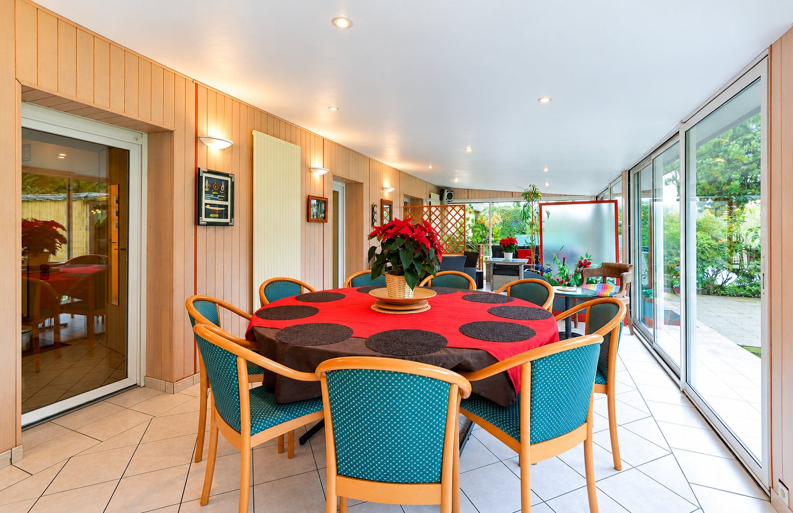 Salle à manger lumineuse avec table ronde rouge et poinsettia